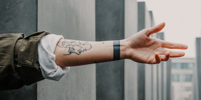 1366x768 Download wallpaper 1366x768 arm, tattoo, wall, blur tablet, laptop