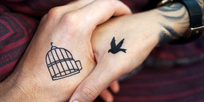 1366x768 Download wallpaper 1366x768 hands, tattoos, couple, love tablet