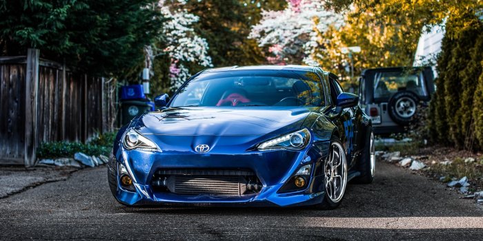 2560x1440 Blue Toyota supra parking on road between trees HD wallpaper download