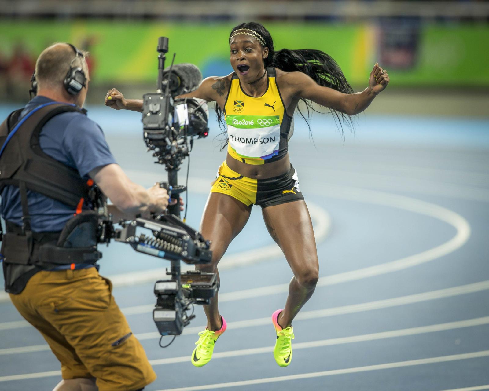 3791x3033 woman in yellow-and-black running gear jumping in front of camera