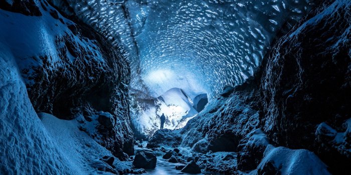 2560x1440 Download wallpaper 2560x1440 glacier, cave, man, ice, snow