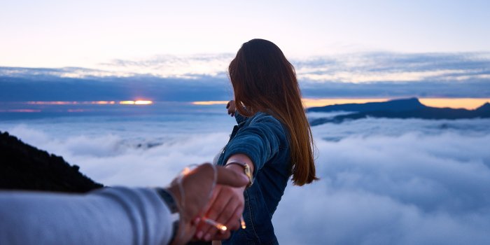 6000x4000 person holding hand woman near cumulus clouds during golden hour