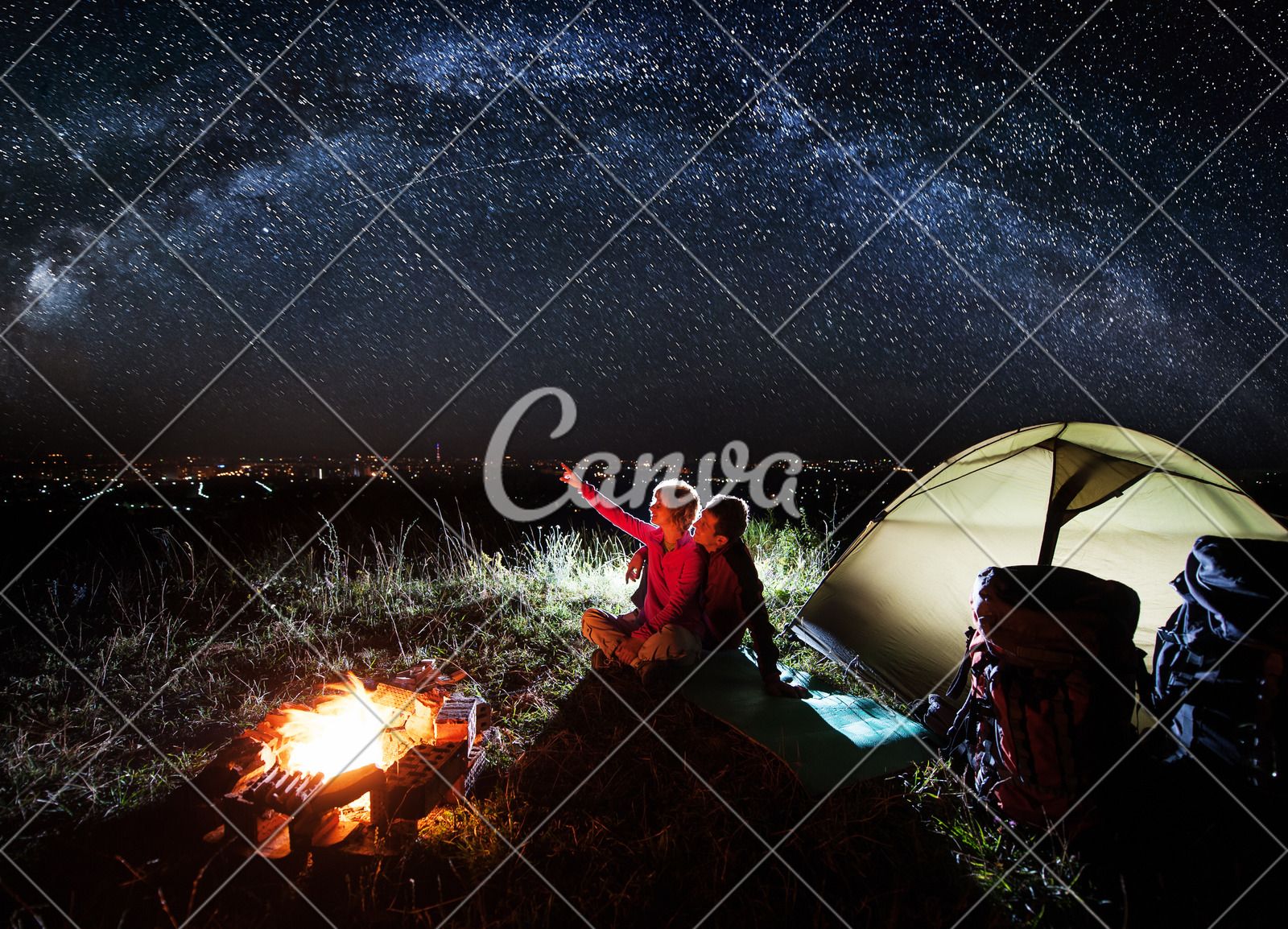 1600x1154 Night camping near the town. Young couple enjoying near campfire and