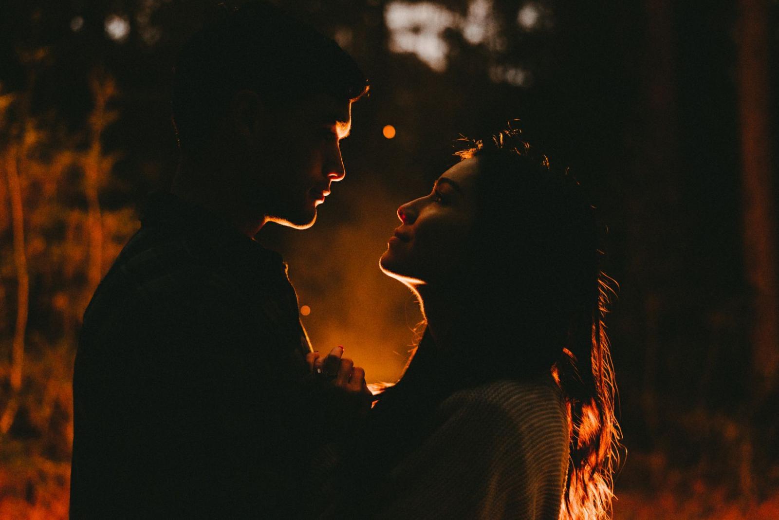 1700x1135 Campfire engagement shoot on the Oregon Coast. Couple is backlit by