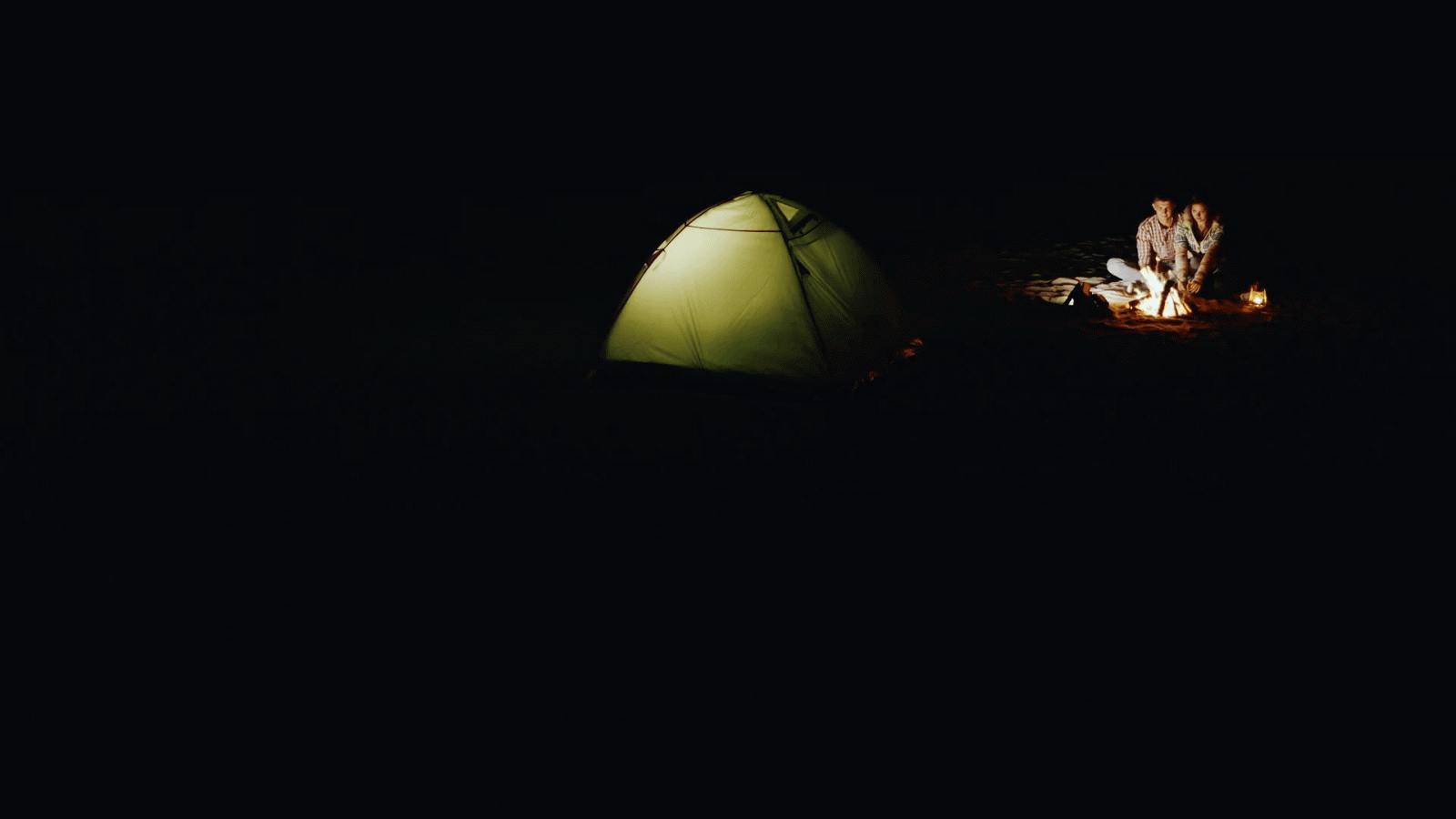 1920x1080 Romantic couple relaxing by the campfire at night, standing next to a tent  in which the light shines Stock Video Footage - Storyblocks Video