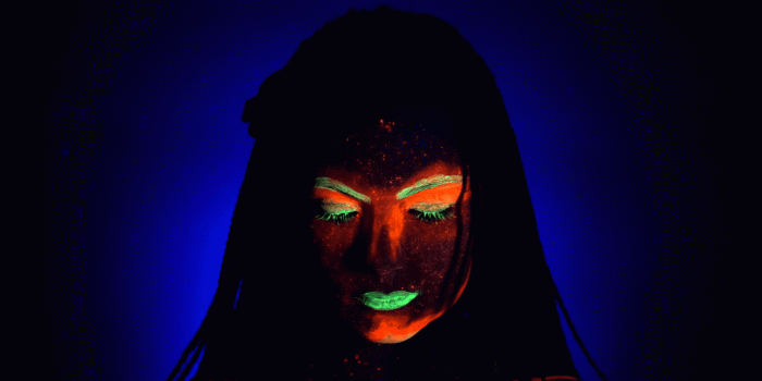 1920x1080 Fashion model woman with braids in neon light. Fluorescent makeup glowing  under UV black light. Night club, party, halloween psychedelic concepts.