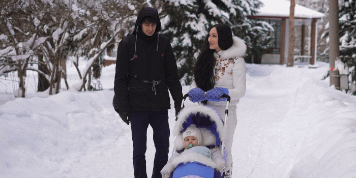 1920x1080 Loving husband and wife communicate cute and smiling during a walk together  with his son in the stroller in the city winter park. Beautiful couple