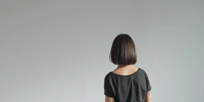 1920x1080 Beautiful young woman with short haircut stands alone lonely on white  isolated wall background, depressed and sad, her best friend blonde girl  comes close to give hug and comfort