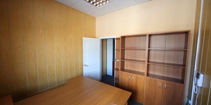 1200x675 A small office room with a work desk and empty cabinets Stock