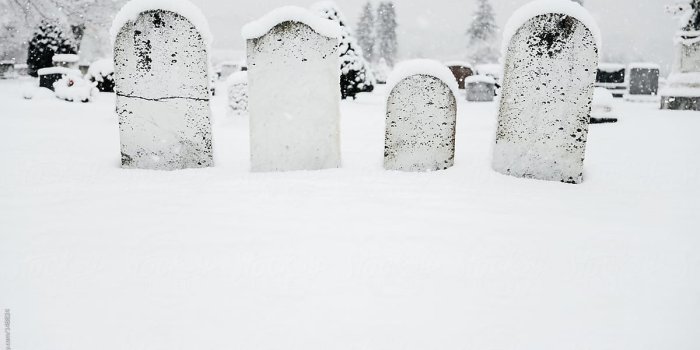 1200x801 Group of four headstones in a cemetery covered in fresh snow by