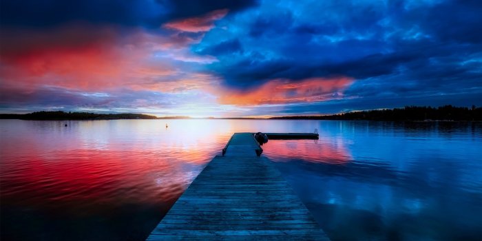 2000x1333 Boat dock station in front of body of water under red and blue sky