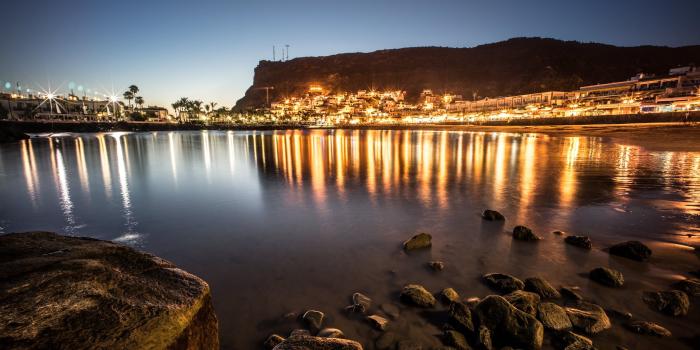 2048x1365 Black rocks on body of water near city lights under blue sky