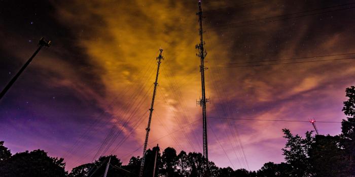 3840x2560 surreal night sky with purple and orange clouds over a suburban