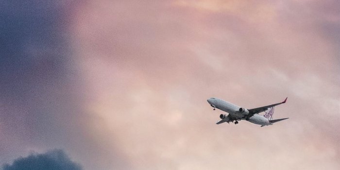 1170x2532 white plane flying over gray clouds iPhone 12 Wallpapers Free Download