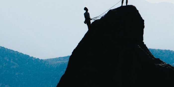 1242x2688 silhouette of two people standing on mountain duri... iPhone X Wallpapers  Free Download