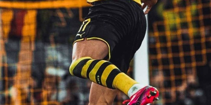 909x1920 Download Erling Haaland Jumping Midair Wallpaper | Wallpapers.com