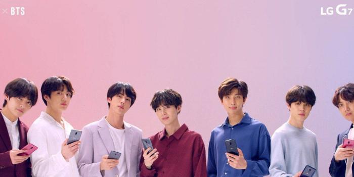 1366x768 Download Bts Holding Lg Phones Laptop Wallpaper | Wallpapers.com