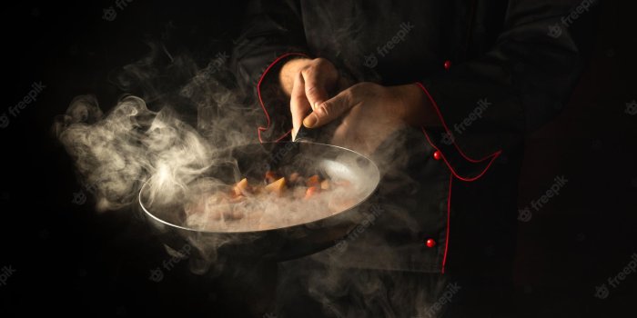 2000x1320 Premium Photo | Professional chef prepares food in a frying pan with steam  on a black background