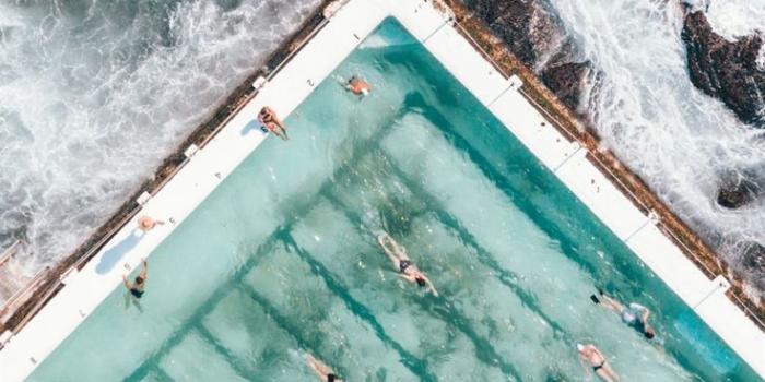 736x1593 pool with people swimming nearby