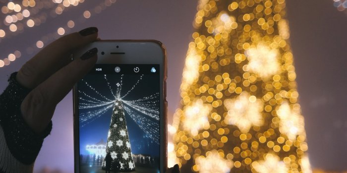 3648x5472 a person taking a picture of their christmas tree with their